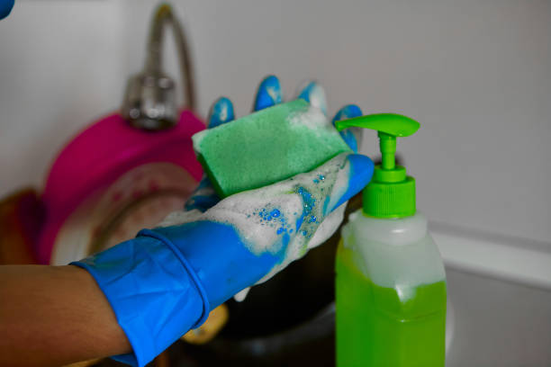 hands in rubber gloves with dish soap and water