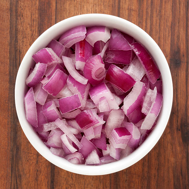 Top view of white bowl full of diced red onions